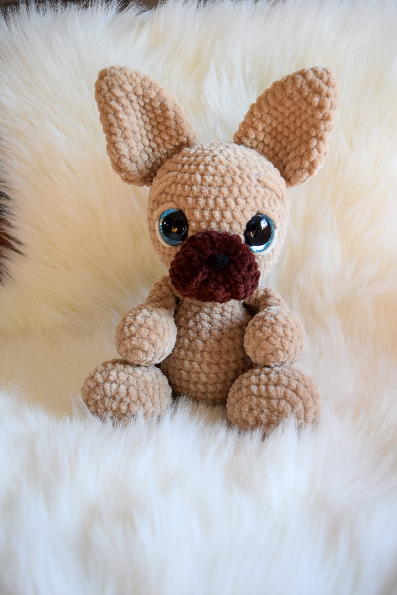 Crocheted dog toy on a fluffy white surface